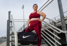brianne wearing a matching maroon workout set from torrid with a nike bag on a bleacher