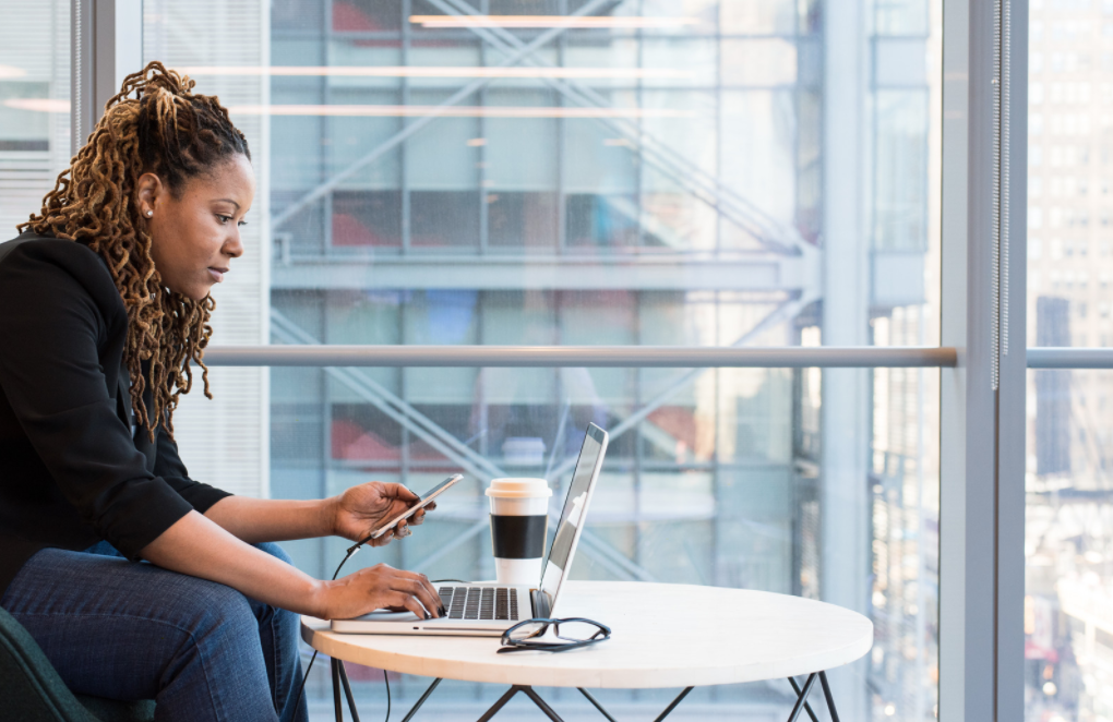 How to Become a Business Consultant - woman on laptop computer with her phone hooked up to it