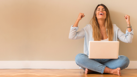 Happy woman smiling wind in her face laptop in her lap