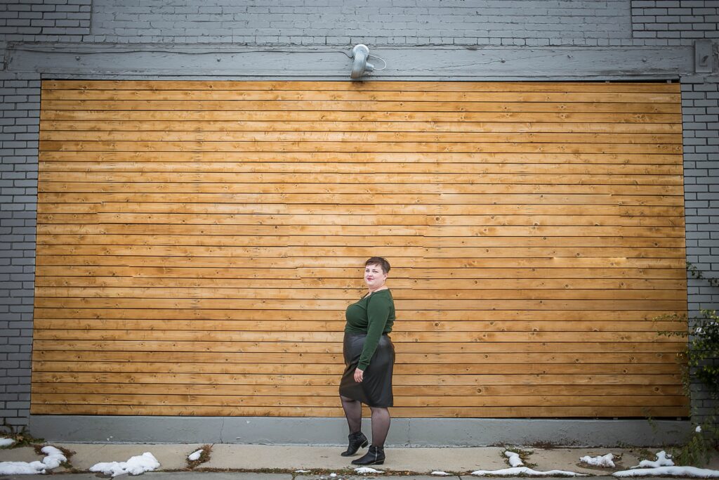 Plus size blogger styling a plus size leather skirt with a sweater and fishnets