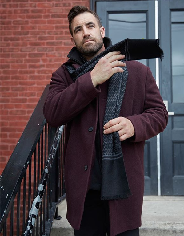 Big and tall business casual outfit featuring a maroon peacoat winter coat with scarf and slacks or dark jeans