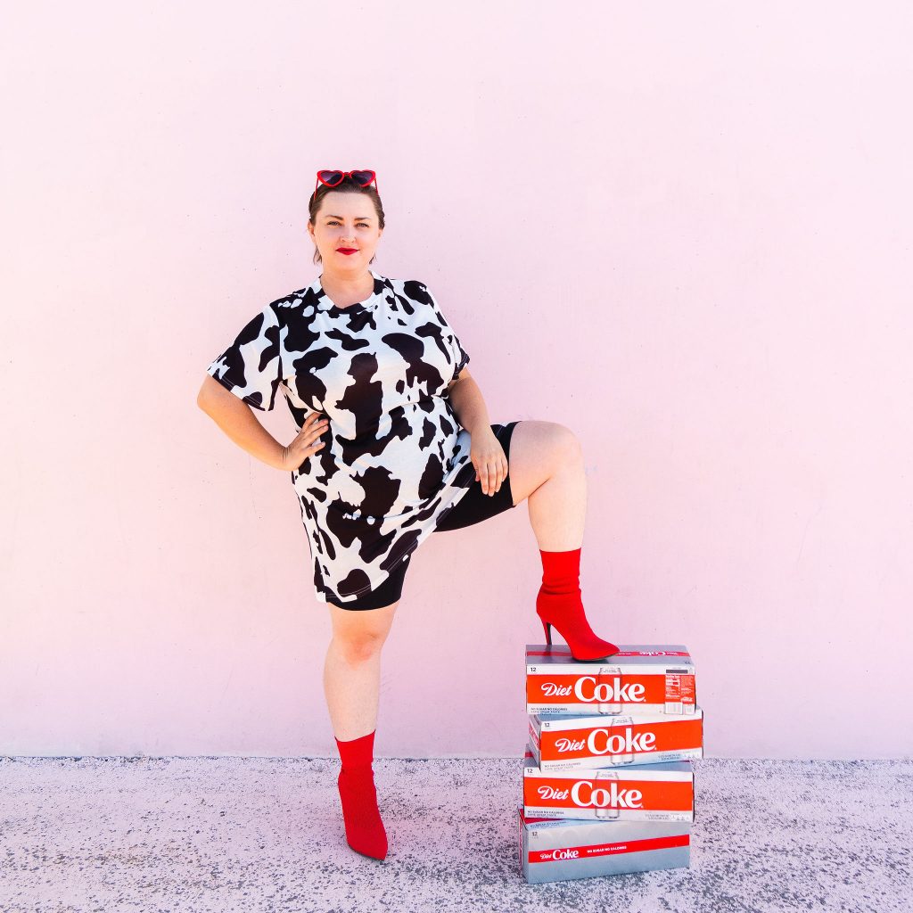 Fashion and lifestyle blogger with diet coke and trendy cow print dress in utah for photoshoot at cents of style