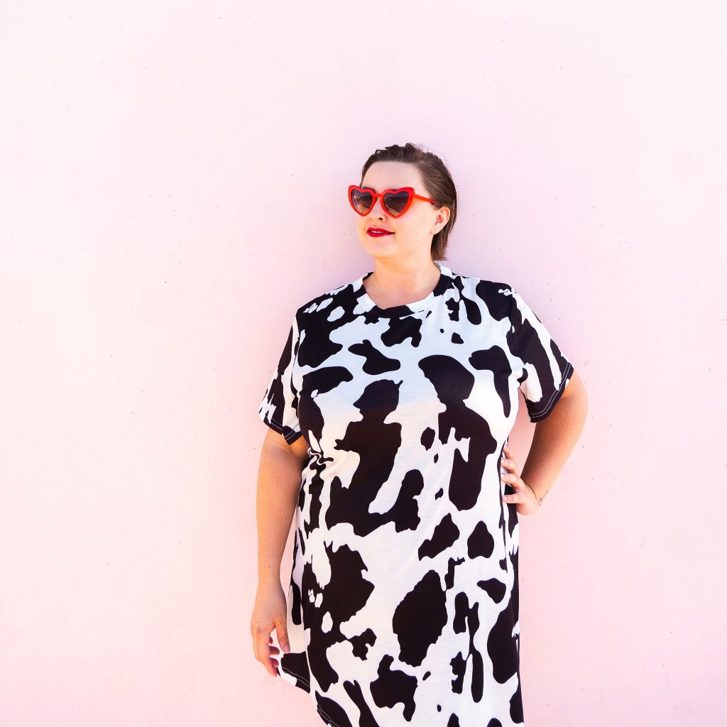 Fashion blogger and model in cowprint dress with red high heel boots