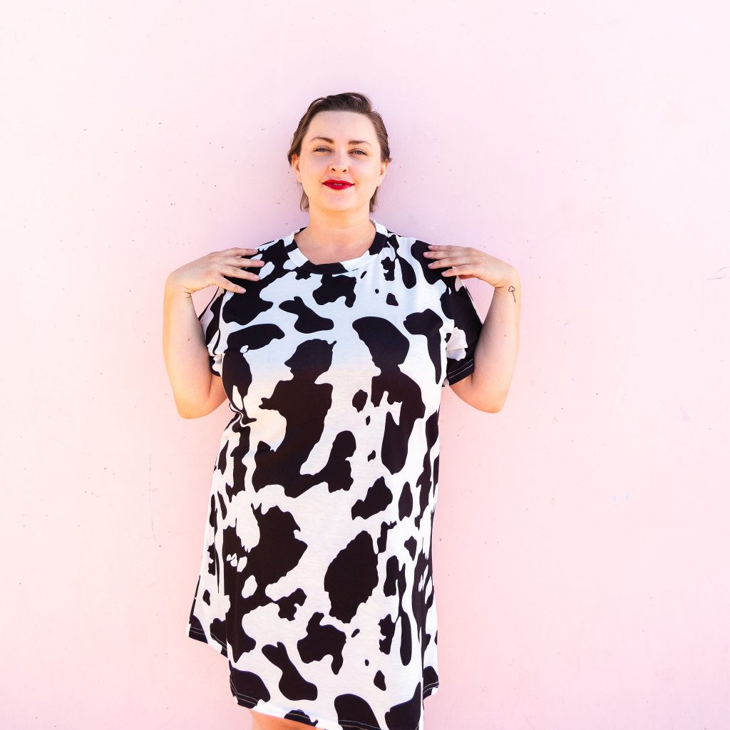 Fashion blogger and model in cowprint dress with red high heel boots