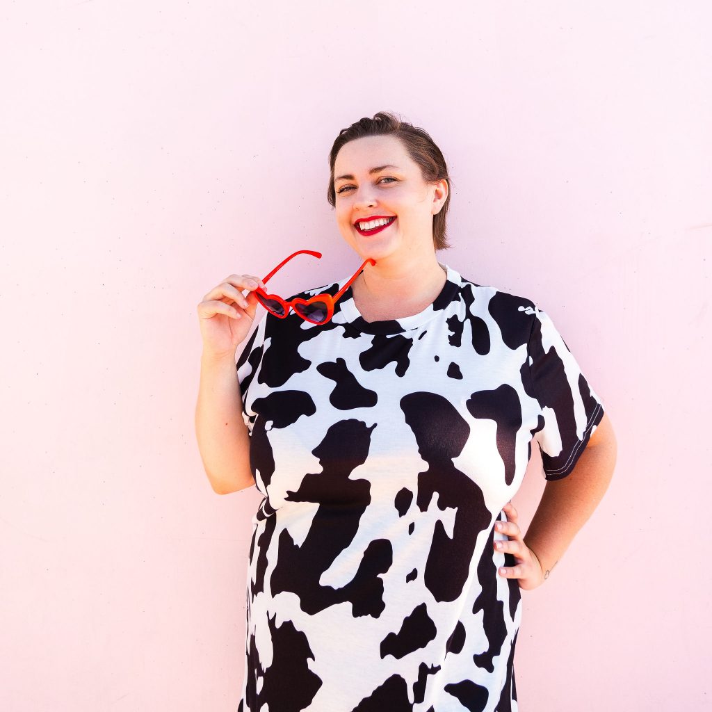 Fashion blogger in cow print t-shirt dress with red boots plus size model