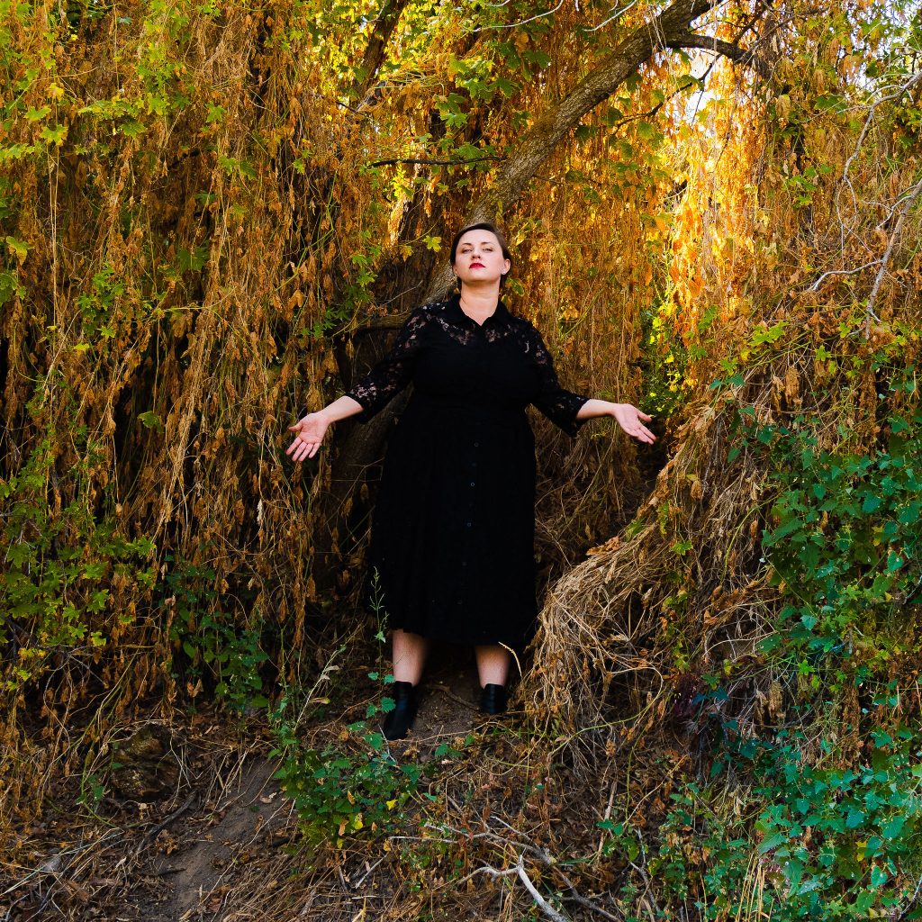 Plus size fall halloween witchy dress in forest with black boots