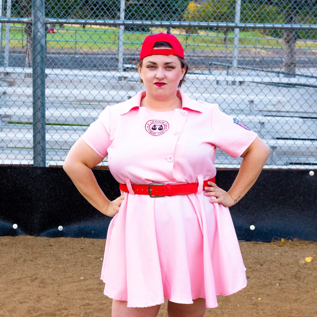 Costume Review - Plus Size a League of Their Own Halloween Costume - pink costume with blogger showing baseball hat on backwards