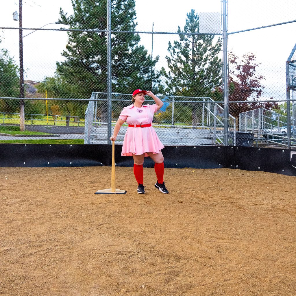 Costume Review - Plus Size a League of Their Own Halloween Costume - pink costume with blogger showing baseball hat on backwards