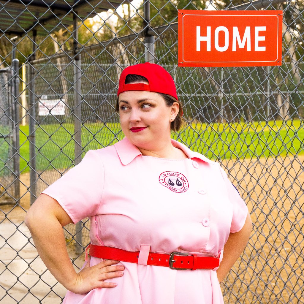Costume Review - Plus Size a League of Their Own Halloween Costume - pink costume with blogger showing baseball hat on backwards