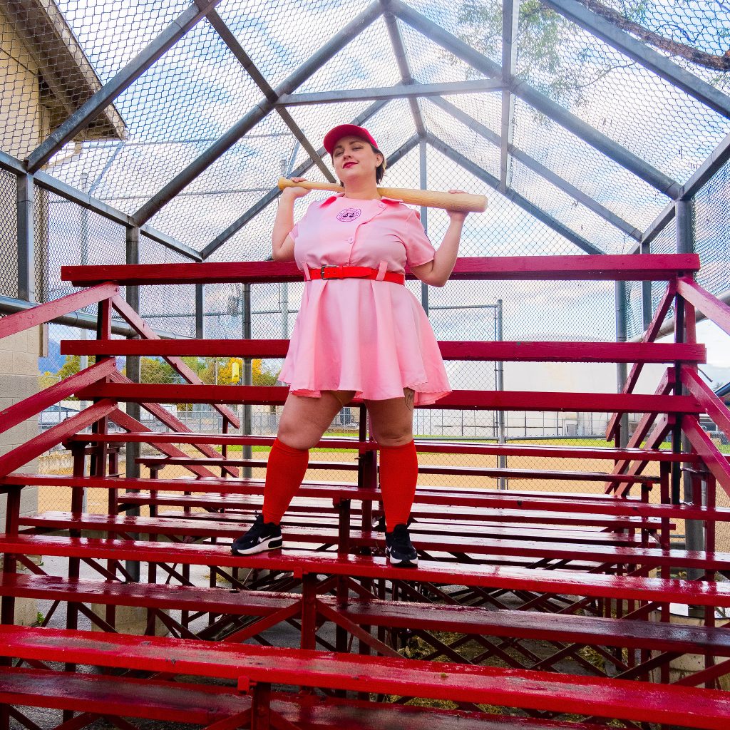 Costume Review - Plus Size a League of Their Own Halloween Costume - pink costume with blogger standing on bleachers