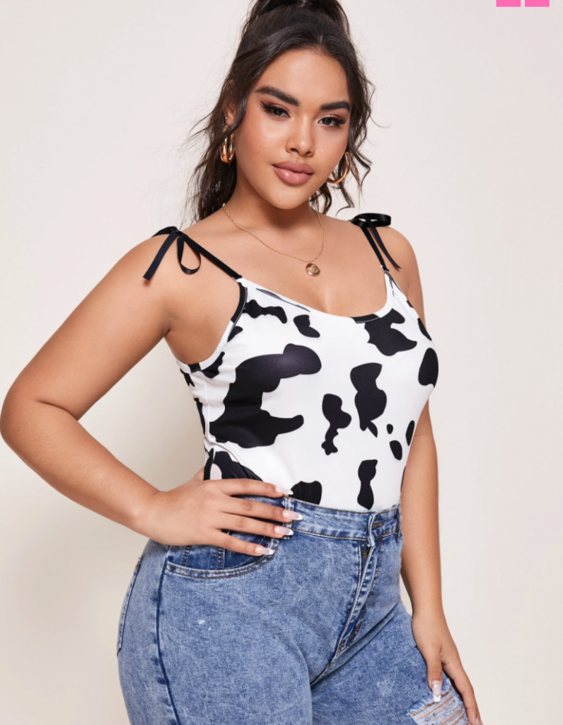 Shopping guide for cow print plus size clothing - image shows a  plus size model wearing jeans and a cow print body suit