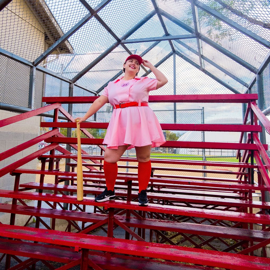 Costume Review - Plus Size a League of Their Own Halloween Costume - pink costume with blogger standing on bleachers