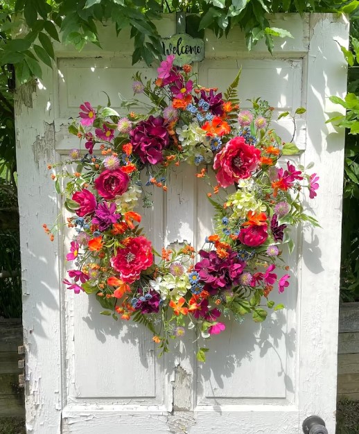 Front Door Wreaths for Summer - gorgeous wildflower wreath featuring bright pink and purple flowers, orange flowers, baby blue flowers and assorted greenery and leaves