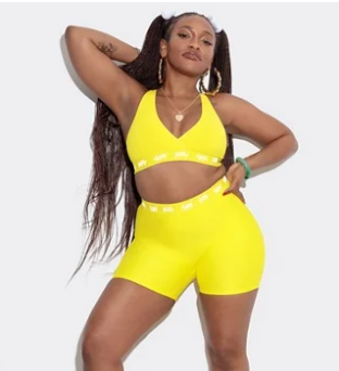 plus size Black  owned brand YITTY - image shows a Black model with pigtail braids in a yellow Yitty high waist bike short and bralette set
